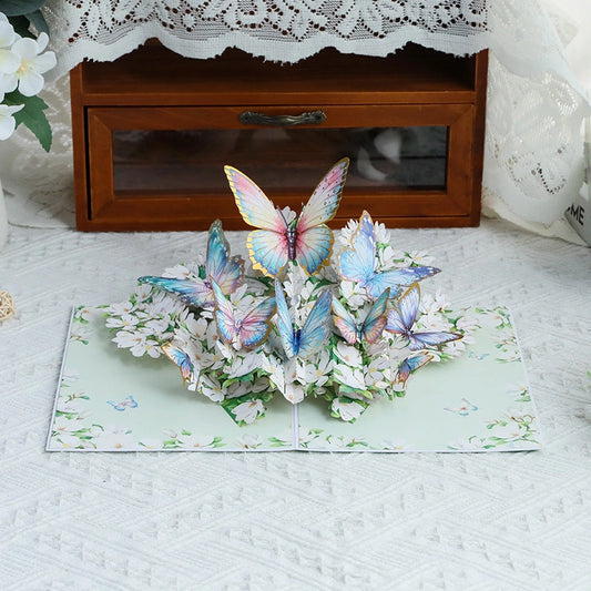 Close-up of intricate paper cut butterflies in blue, pink, and yellow resting on white floral bouquet