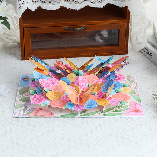 Side view of 3D butterfly and rose pop-up card displayed on a table, showing depth of paper art