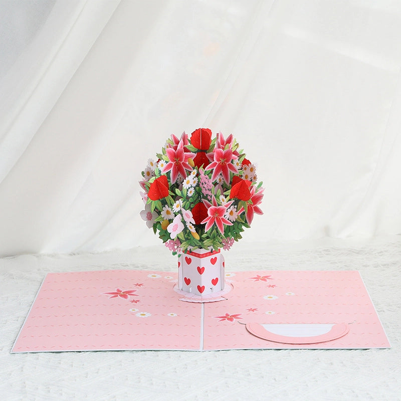 3D pop-up greeting card opening to reveal a large bouquet of red roses and pink lilies in a white vase with red hearts