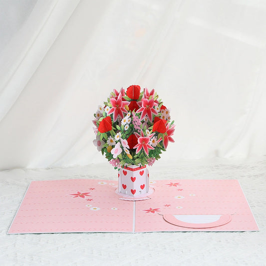 3D pop-up greeting card opening to reveal a large bouquet of red roses and pink lilies in a white vase with red hearts