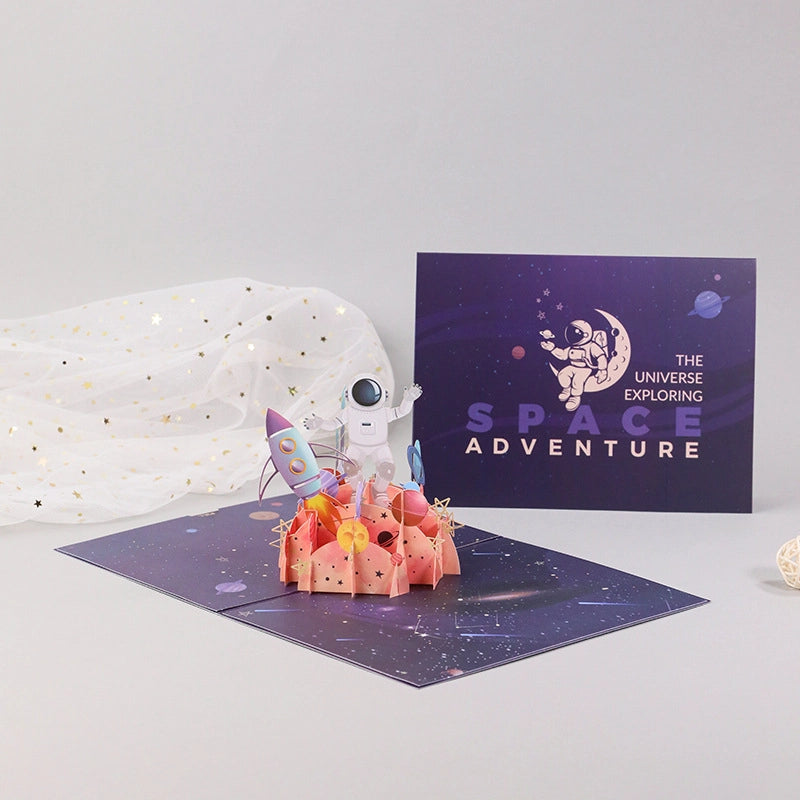 3D pop-up space adventure greeting card featuring an astronaut, rocket, colorful planets and a galaxy scene