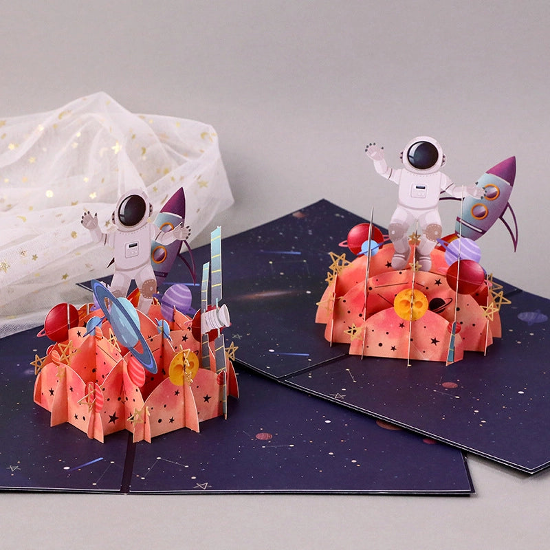 3D pop-up space cards featuring astronauts, rockets, planets and colorful galaxy-themed designs