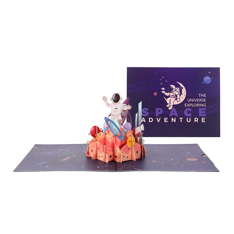 Open 3D pop-up space adventure greeting card with astronaut, rocket and planets on a starry galaxy background