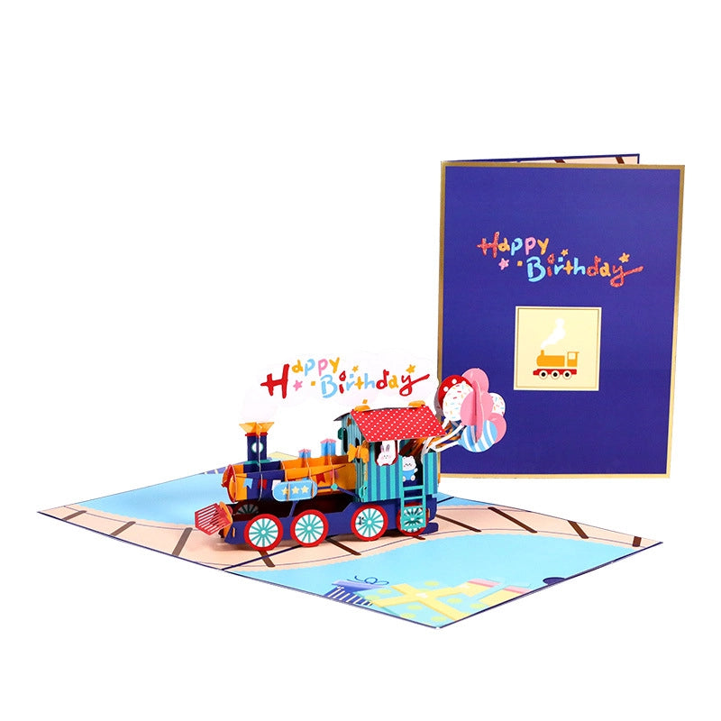 3D pop-up birthday card featuring a colorful steam train with "Happy Birthday" smoke, cute bunnies, and balloons