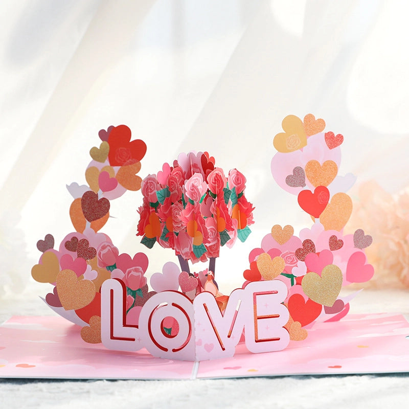 Close-up of 3D pop-up card featuring pink paper roses and colorful heart shapes with LOVE text