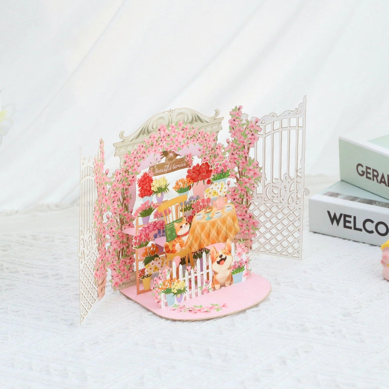 Side angle of the Beautiful Garden card displaying the depth of the white iron gates and cherry blossom arches