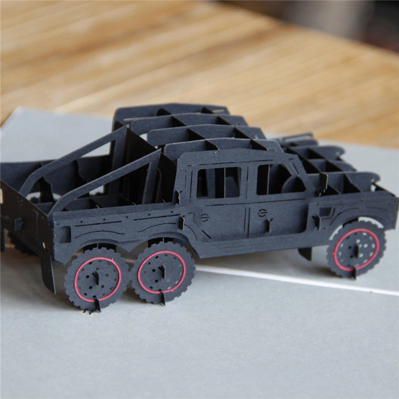 Detailed 45-degree view of the 3D pop-up black SUV card, showcasing the depth of the paper engineering and the red rim accents on the tires.