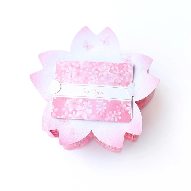 Top view of the closed cherry blossom shaped card cover with a "For You" belly band wrapper, pink floral pattern
