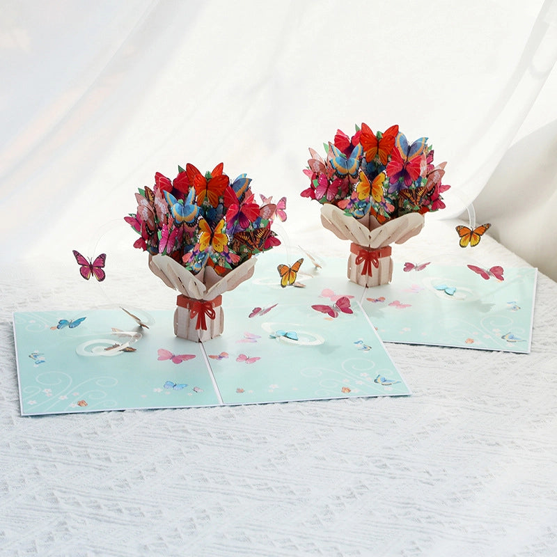 Light blue card cover featuring a printed illustration of a butterfly bouquet with a pink ribbon.