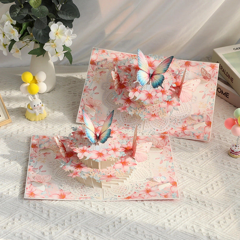 Two open butterfly pop-up cards showing intricate paper art design
