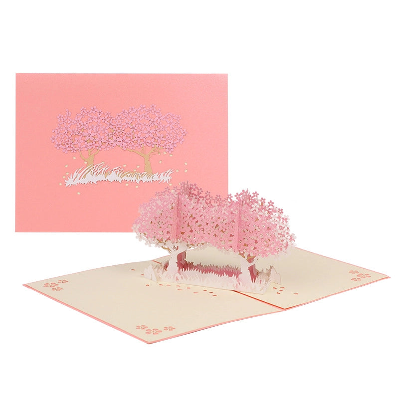 Full view of the closed and open cherry blossom 3D pop-up card, showing the pink cover with gold-embossed sakura design and the vibrant 3D interior, ideal for wedding or Valentine's Day gifting.