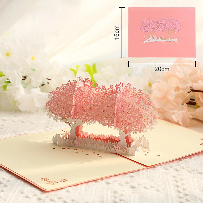 Dimensional diagram of the cherry blossom 3D pop-up card with measurements (15cm x 20cm closed, 7.6cm x 12.4cm inner panel), displayed alongside the open card to illustrate size and structure for online shoppers.