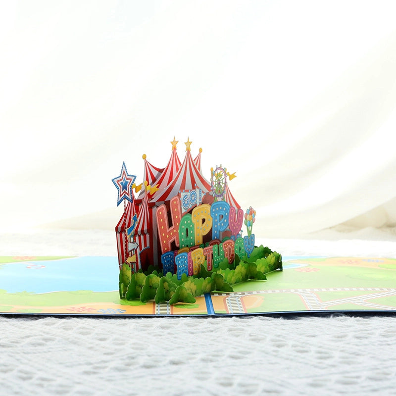 Side view of 3D paper cut circus tent birthday card showing intricate layers and colorful "Happy Birthday" lettering
