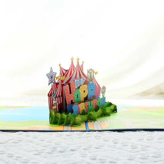 Side view of 3D paper cut circus tent birthday card showing intricate layers and colorful "Happy Birthday" lettering

