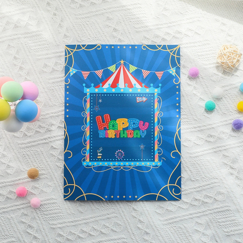 Blue greeting card cover featuring a red and white striped circus tent illustration with "Happy Birthday" text and gold border
