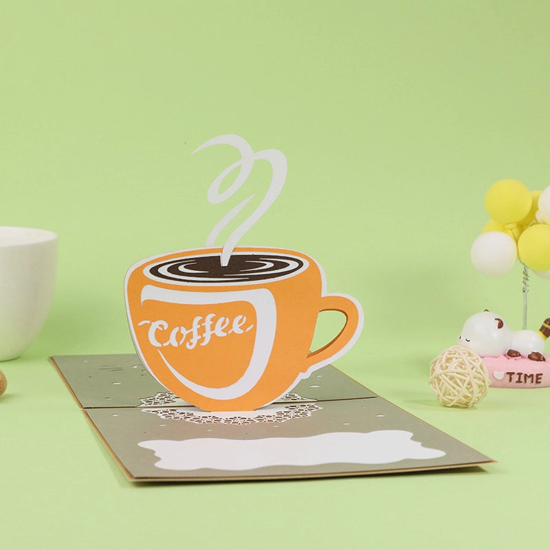 Kraft paper cover of a greeting card with silver foil stamping of a coffee cup and text "Have a cup!".
