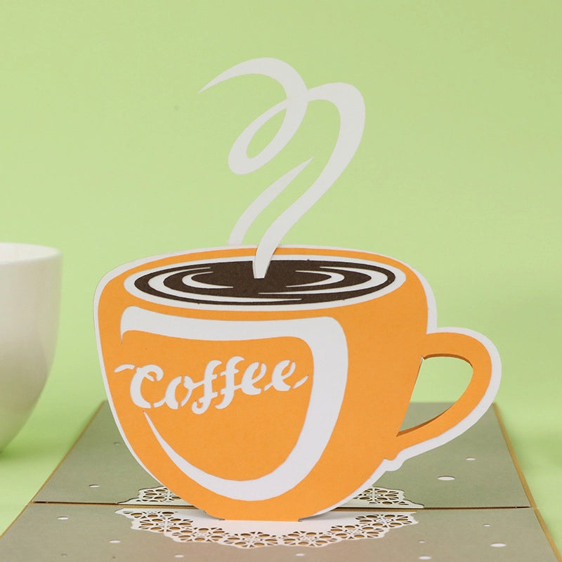 Kraft paper cover of a greeting card with silver foil stamping of a coffee cup and text "Have a cup!".
