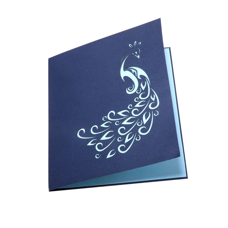 Closed dark blue greeting card featuring an elegant silver foil peacock illustration