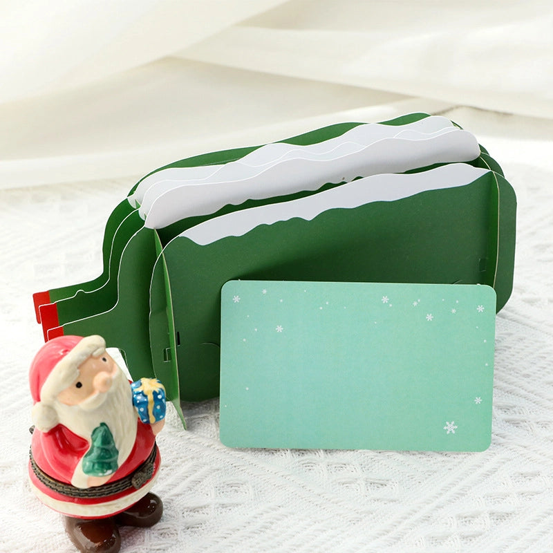 Back view of the Christmas card showing a light green snowflake pattern design, placed next to a matching blank message card.