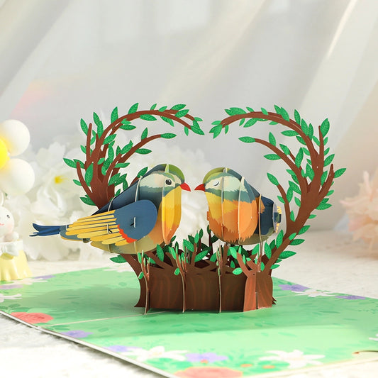 3D pop-up card featuring two love birds on a heart-shaped tree branch with floral border