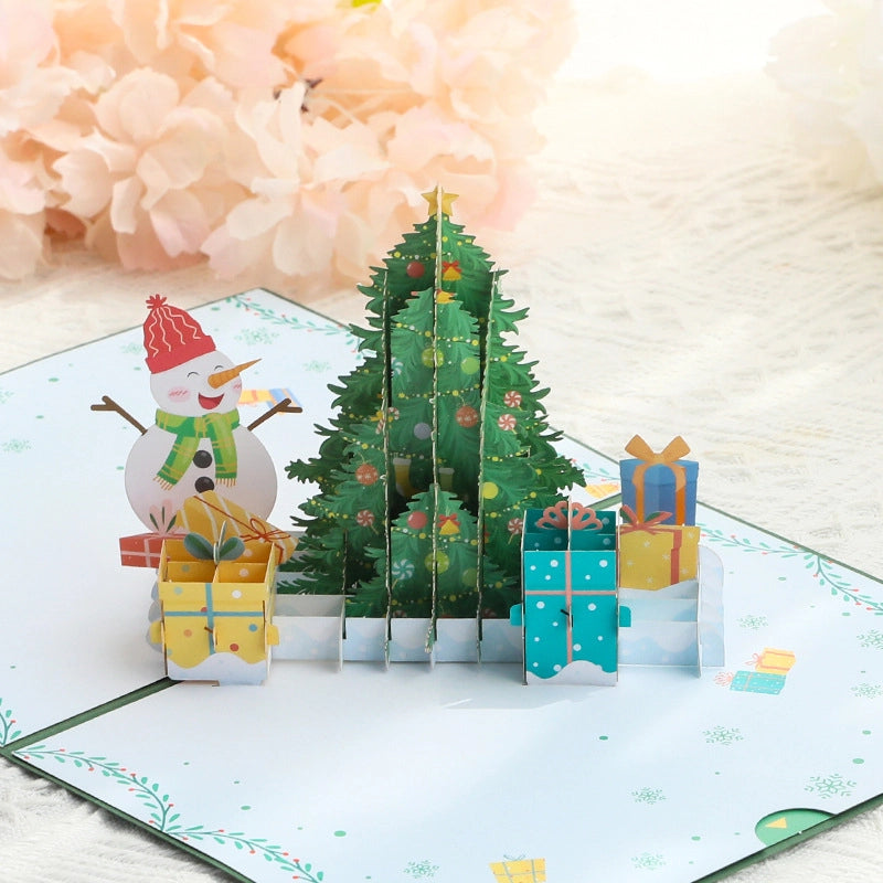 Close-up of 3D Christmas tree pop-up card with snowman and presents