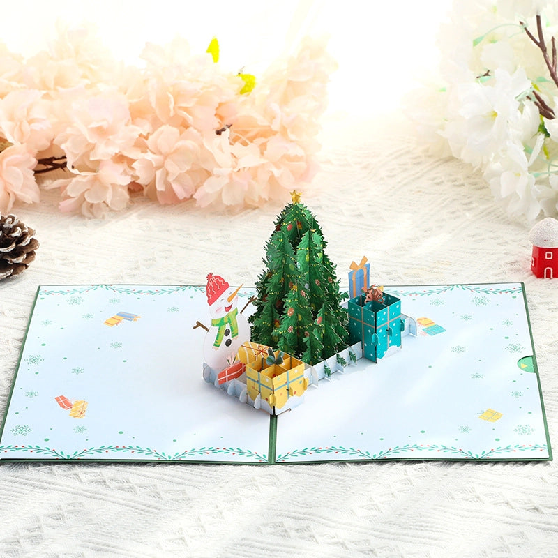 Open Christmas pop-up greeting card displaying a festive 3D Christmas scene
