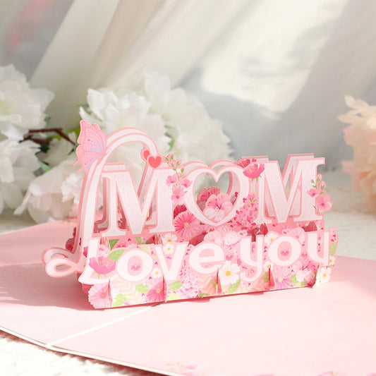 Close up of Mom Love You 3D greeting card with pink cherry blossoms and butterfly decoration for Mother's Day
