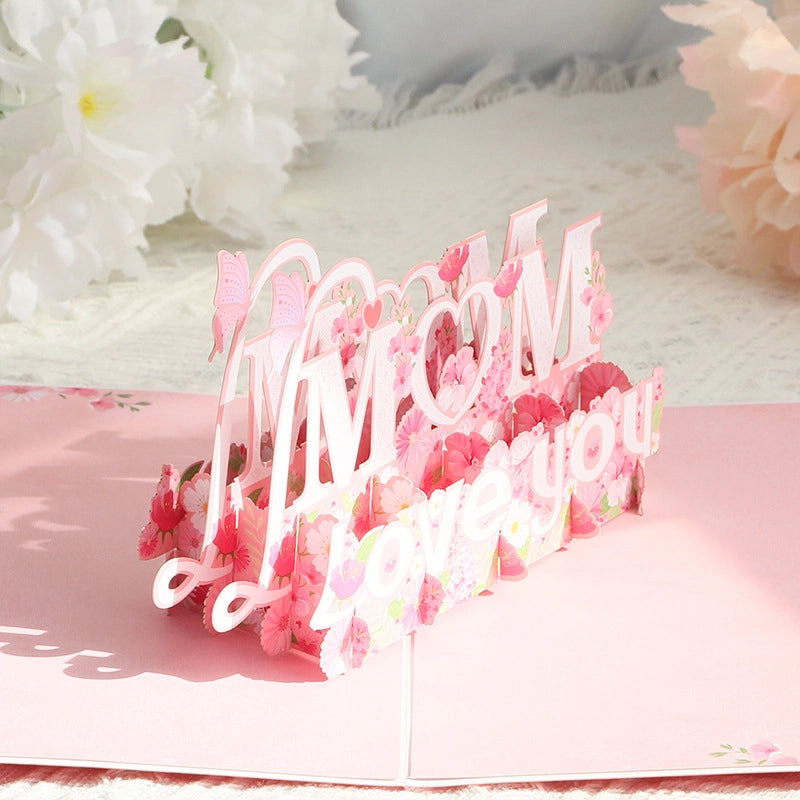Inside view of flat pop-up card showing red paper engineering mechanism and floral corners
