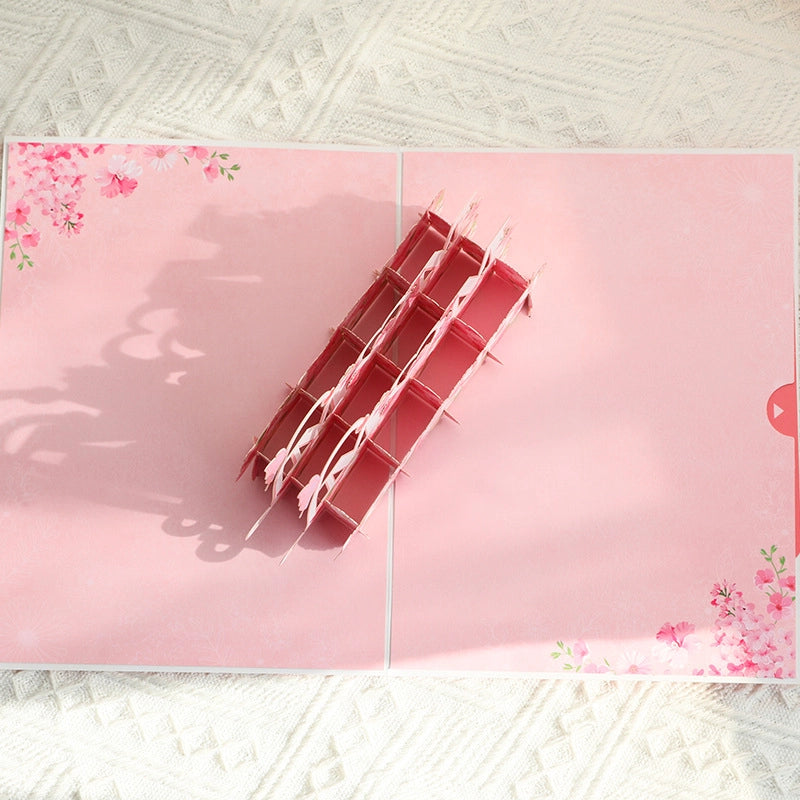 Side view of pink floral pop-up card revealing intricate paper cut layers and 3D structure
