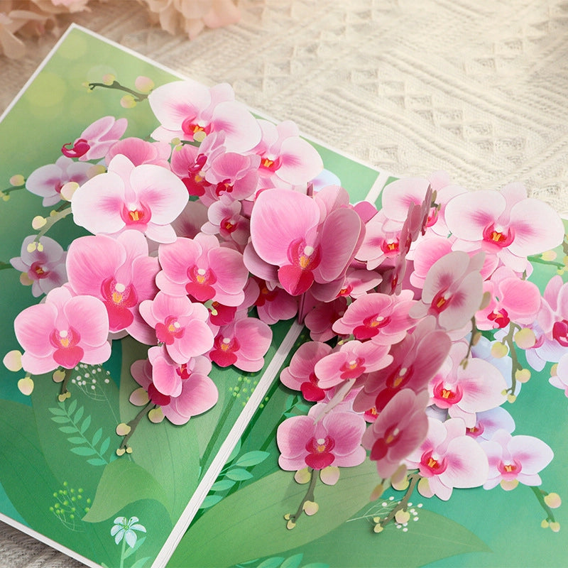 Detail view of layered paper orchid petals and green leaves