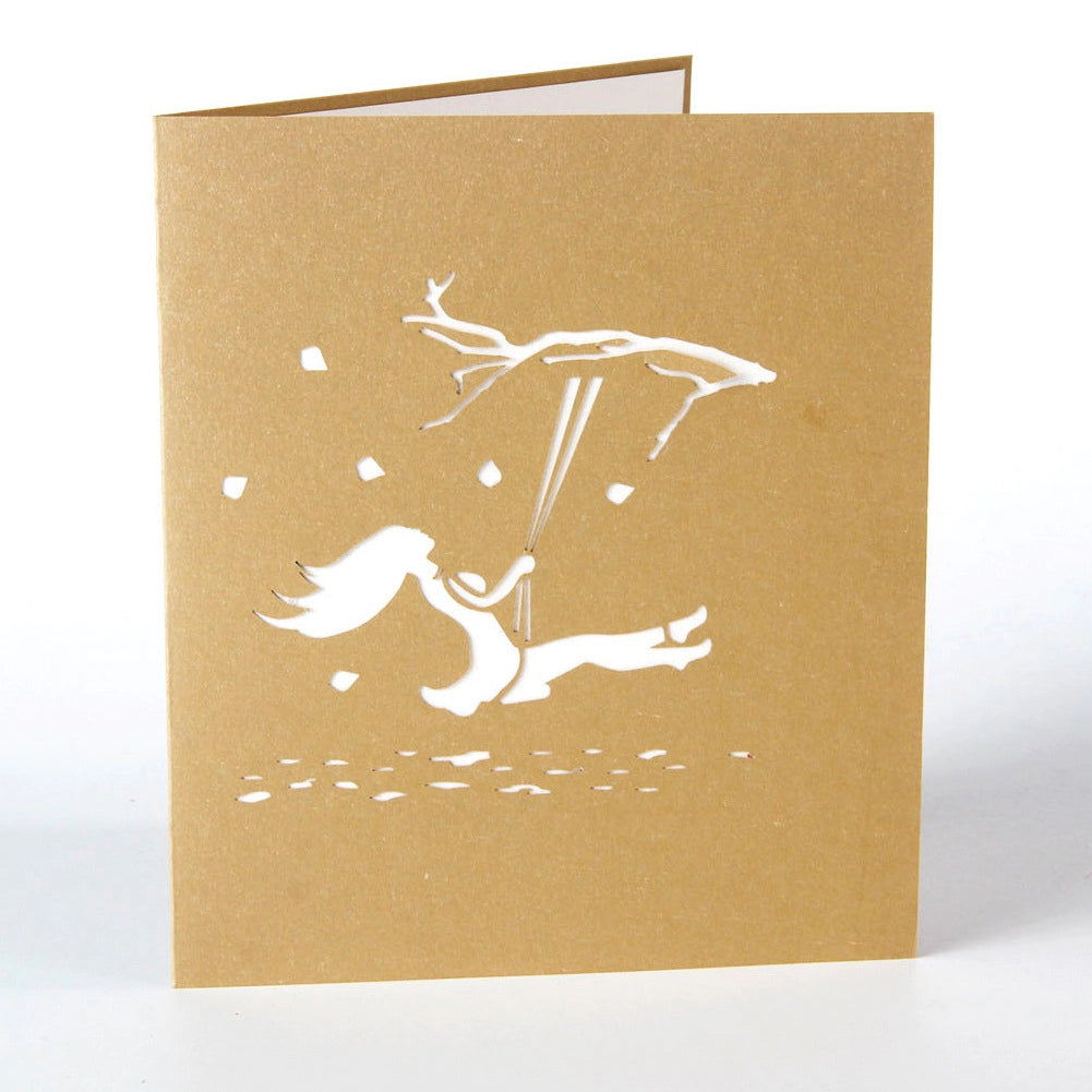 Kraft paper greeting card cover with white laser-cut silhouette of a girl flying with deer antlers
