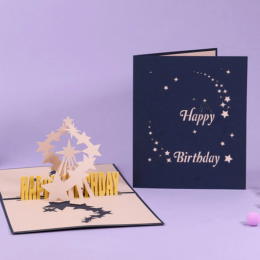 White background product shot showing both the closed navy blue cover and the open 3D starry birthday card mechanism.