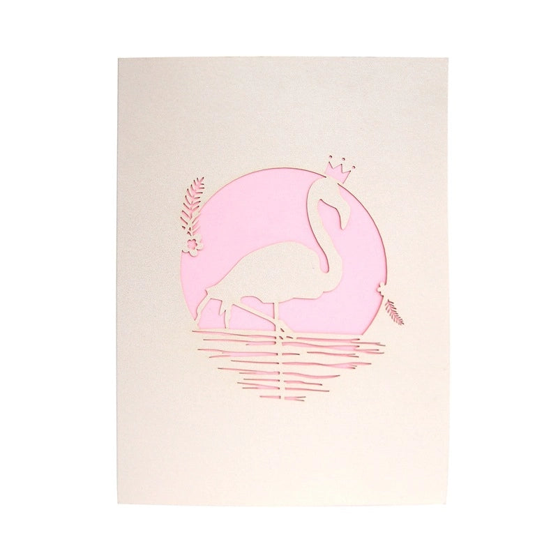 Front cover of the greeting card featuring a delicate laser-cut design of a flamingo wearing a crown inside a pink circle on cream cardstock.