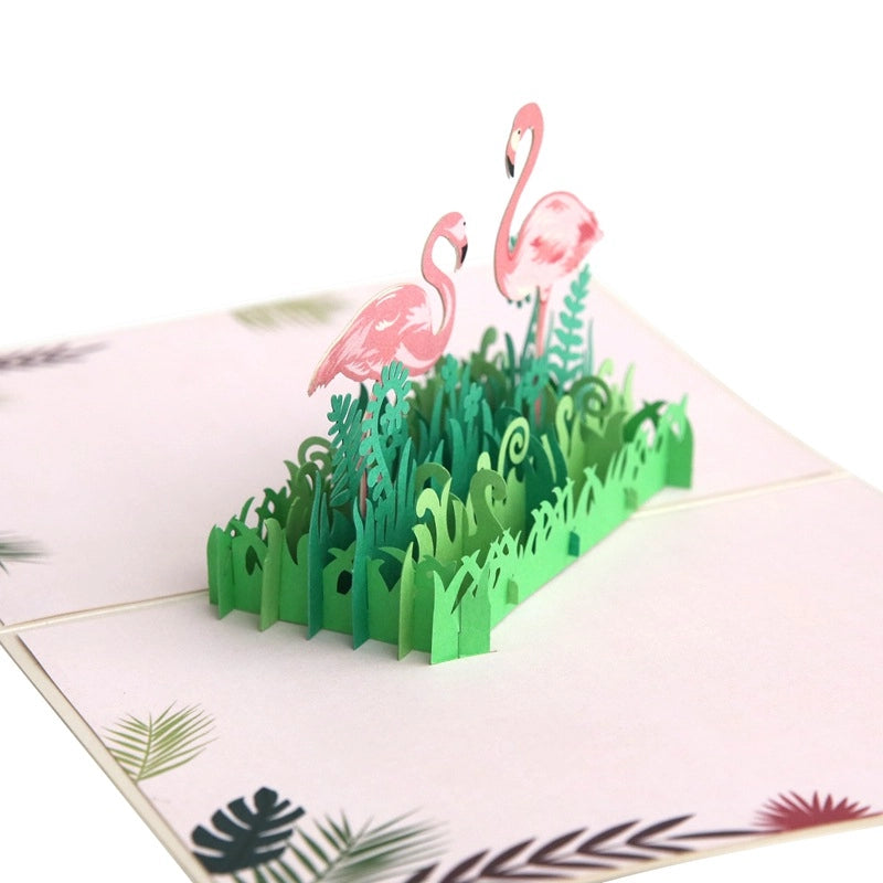 Angled view of the tropical pop-up card showing the depth of the 3D scene and the palm leaf patterns printed on the inner card panels.